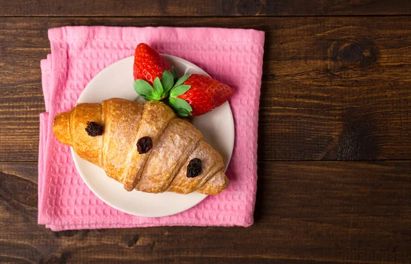 Heerlijk ontbijt met verse croissants en rijpe bessen op oude houten achtergrond, selectieve aandacht, bovenaanzicht — Stockfoto