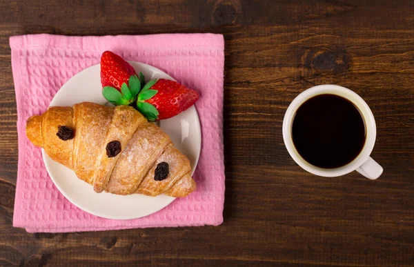 Färska franska croissant och jordgubb. kopp kaffe. träbord bakgrund. Ovanifrån — Stockfoto