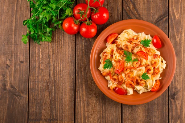 Fettuccine pasta con tomates camarones y hierbas. fondo de madera — Foto de Stock