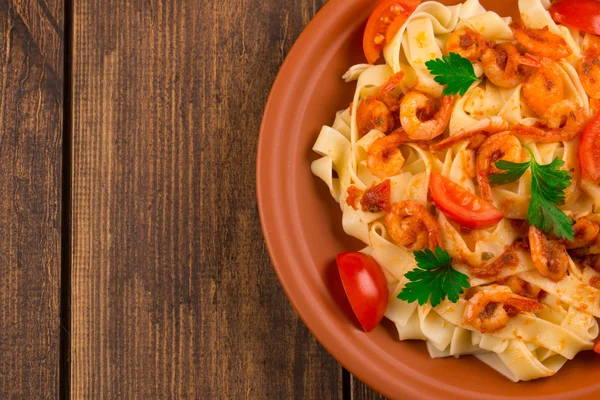 Fettuccine ζυμαρικά με γαρίδες ντομάτες και μυρωδικά. ξύλινο υπόβαθρο — Φωτογραφία Αρχείου