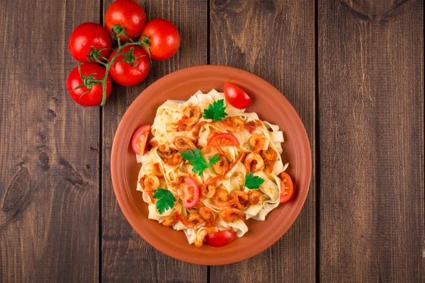 Fettuccine pasta con tomates camarones y hierbas. fondo de madera — Foto de Stock