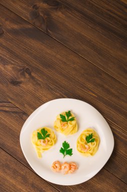 makarna karides bir ahşap zemin üzerine maydanoz ile dekore edilmiştir.