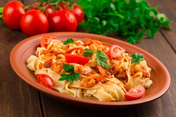 Fettuccine pasta con tomates camarones y hierbas. fondo de madera — Foto de Stock