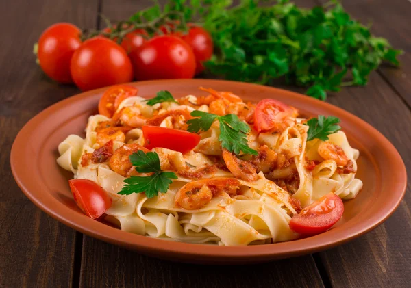 Fettuccine pasta con tomates camarones y hierbas. fondo de madera — Foto de Stock