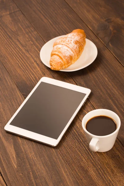 Чашка кофе на столе в кафе с планшетом — стоковое фото