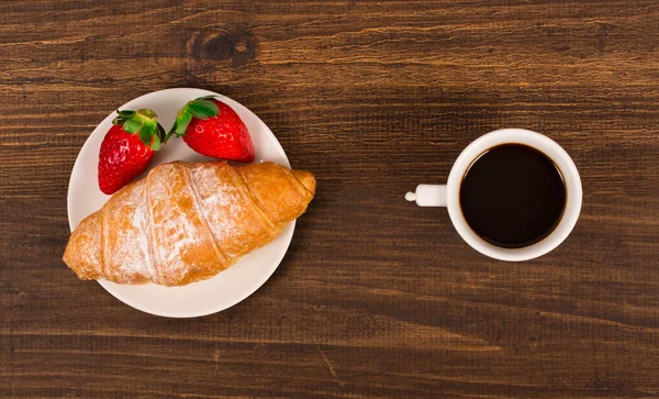 Kontinental frukost med croissanter, kaffe och färska jordgubbar. ovanifrån — Stockfoto