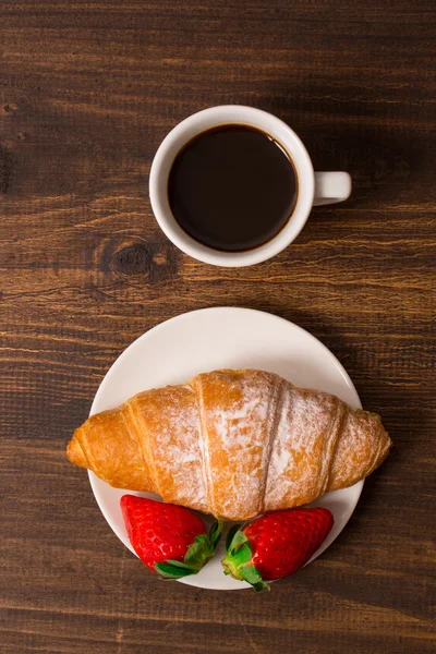 Kontinentales Frühstück mit Croissant, Kaffee und frischen Erdbeeren. Ansicht von oben — Stockfoto
