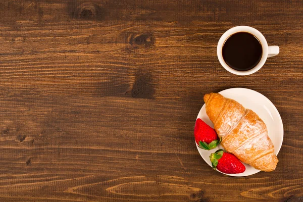 Kontinentales Frühstück mit Croissant, Kaffee und frischen Erdbeeren. Ansicht von oben — Stockfoto