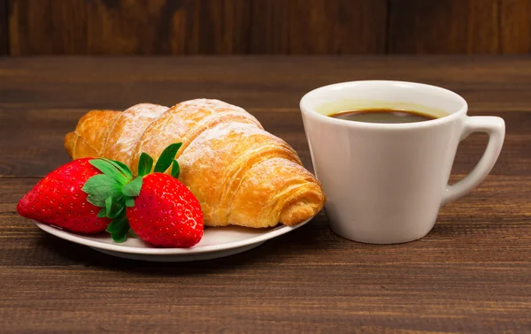 Kontinental frukost med croissanter, kaffe och färska jordgubbar. — Stockfoto
