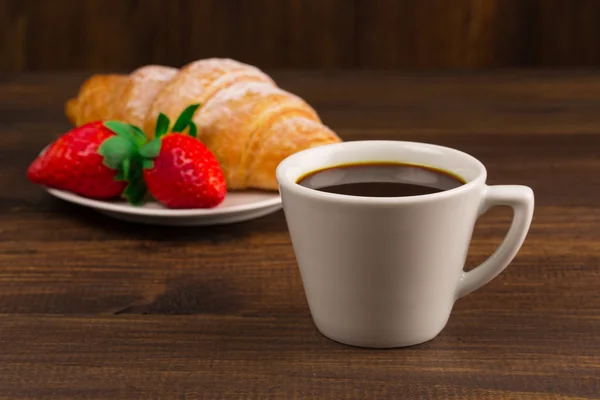 Kontinental frukost med croissanter, kaffe och färska jordgubbar. — Stockfoto