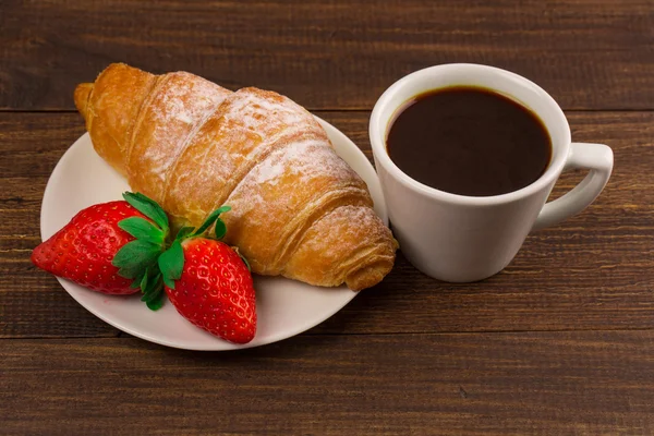 Kontinental frukost med croissanter, kaffe och färska jordgubbar. — Stockfoto