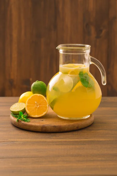 Taze limonlu limonata ve ahşap arka planda cam sürahi içinde nane.