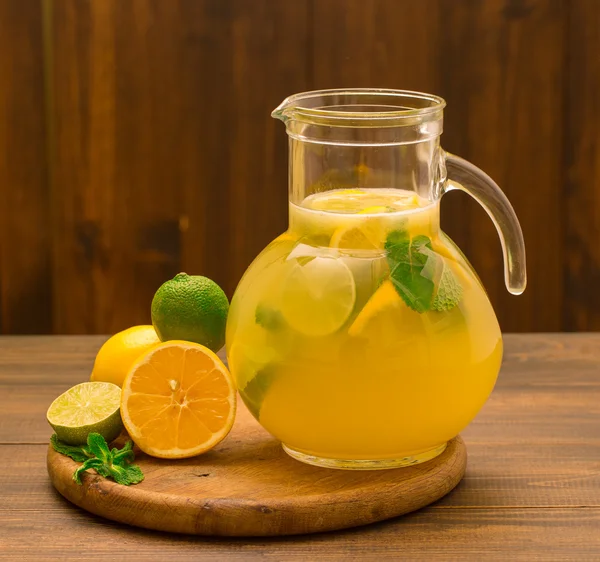 Taze limonlu limonata ve ahşap arka planda cam sürahi içinde nane.