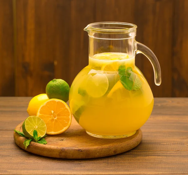Taze limonlu limonata ve ahşap arka planda cam sürahi içinde nane.