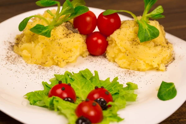 Salat mit Tomaten in Form von Marienkäfern mit Kartoffelpüree — Stockfoto