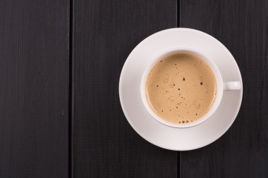 Kapuçino tarçın beyaz bir fincan ile. Siyah ahşap masa kahve