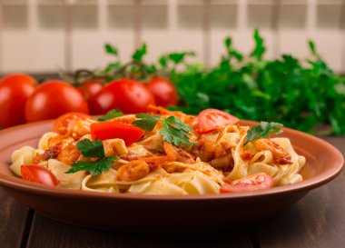 Fettuccine makarna karides domates ve otlar ile. ahşap arka plan