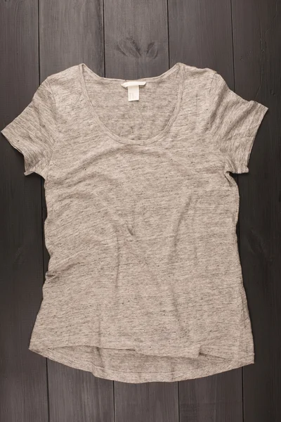 Camisa cinza sobre fundo de madeira — Fotografia de Stock