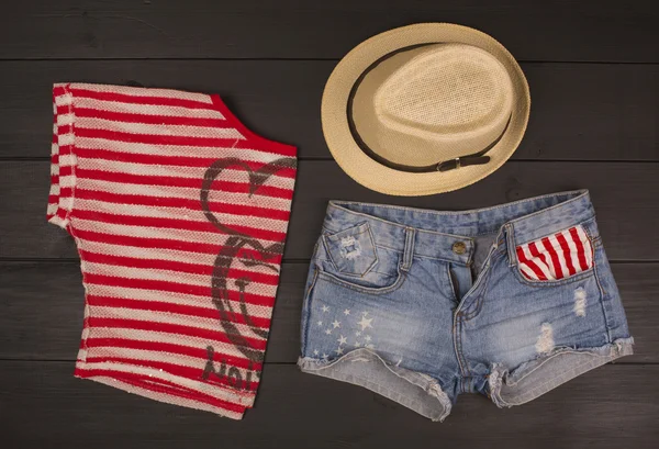 Ahşap bir arka planda hippi kıyafetleri ve aksesuarlar.