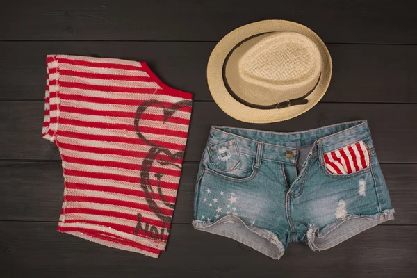 Ahşap bir arka planda hippi kıyafetleri ve aksesuarlar.