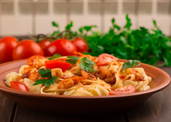 Fettuccine pasta con tomates camarones y hierbas. fondo de madera —  Fotos de Stock