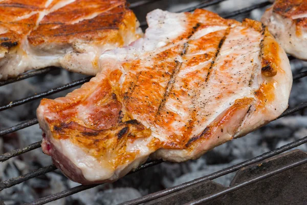 Rindersteak vom Grill. Steaks auf flammendem Grill grillen und zielgerichtet schießen — Stockfoto