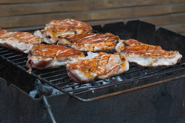 Bife grelhado na grelha. bifes grelhados na grelha flamejante e tiro com foco seletivo — Fotografia de Stock