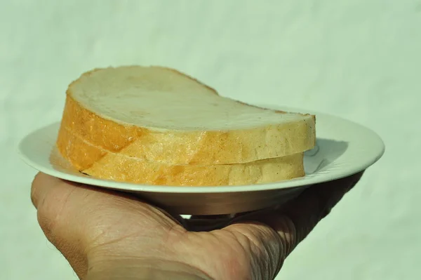 Λευκό Μέλι Φέτες Λευκού Ψωμιού Ένα Πιάτο Τεντωμένο Χέρι Λευκό — Φωτογραφία Αρχείου