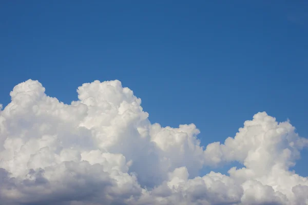 Μπλε του ουρανού με πρησμένα άσπρα σύννεφα στα φωτεινά σαφή ηλιόλουστη ημέρα — Φωτογραφία Αρχείου