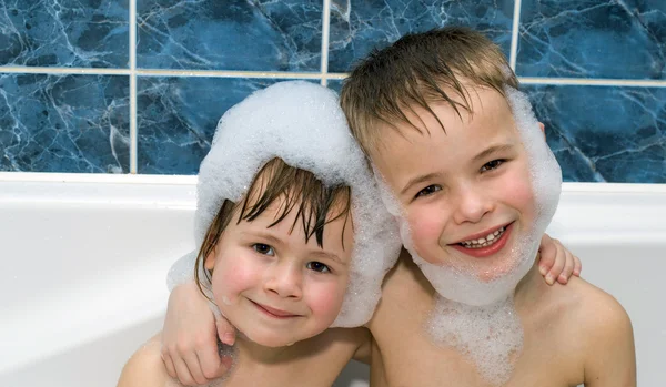 Zwei kleine Kinder in einer Badewanne mit Shampoo-Schaum — Stockfoto
