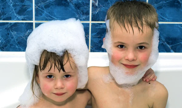 Two little children in a bathtub with shampoo foam — Stock Photo, Image