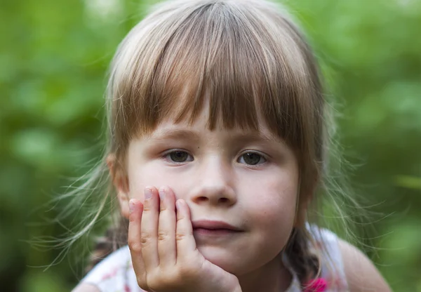 Yeşil arka plan bulanık üzerinde küçük bir kız portresi — Stok fotoğraf