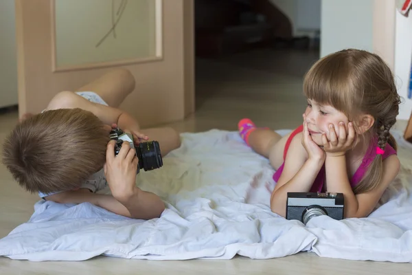 Маленький мальчик фотографирует маленькую девочку — стоковое фото