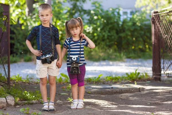Chlapeček a holčička vtip dvou vintage fotoaparáty stojící — Stock fotografie