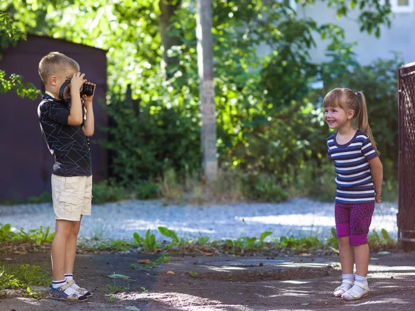 Malý chlapec vyfotit litthe dívku na slunné letní d — Stock fotografie