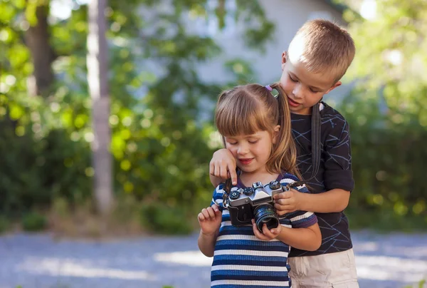 Niño y niña aprendiendo a usar la cámara fotográfica — Foto de Stock