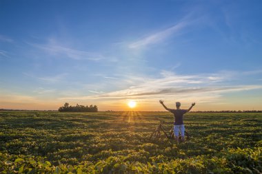 Sabah Sunrise seninki ile ayakta Bisiklet yakınındaki genç adam