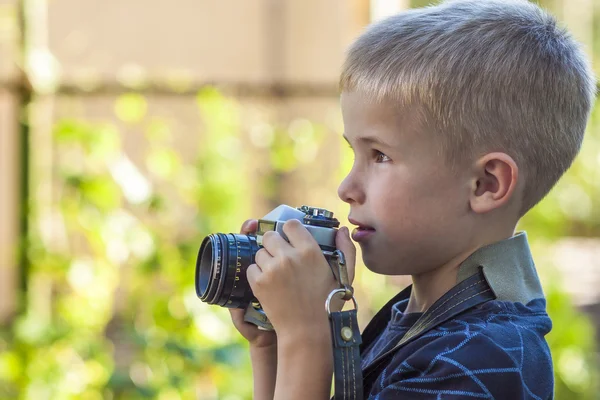 Carino piccolo ragazzo felice con fotocamera vintage all'aperto — Foto Stock