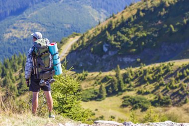 Bir sırt çantası konumu dağlarda olan uzun yürüyüşe çıkan kimse