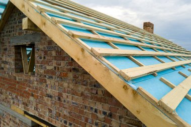 Ahşap çatı iskeleti olan tuğladan bir evin havadan görünüşü.