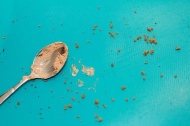 Mavi fotokopi arkaplanında çikolata kremalı kaşık. Mutfak, fırın ve lezzetli tatlı konsepti..