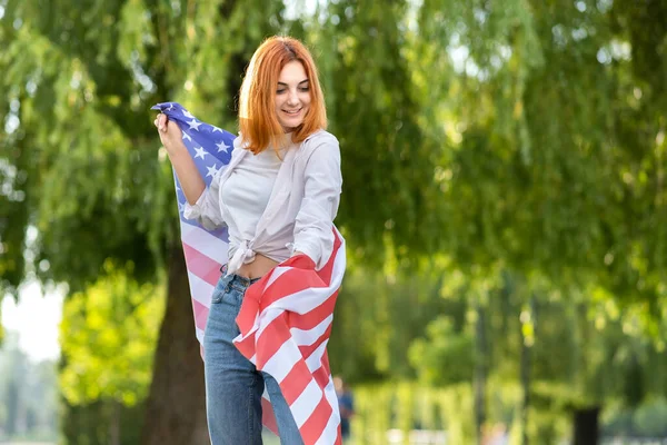 Szczęśliwa Młoda Ruda Kobieta Pozująca Flagą Usa Ramionach Stojąca Świeżym — Zdjęcie stockowe