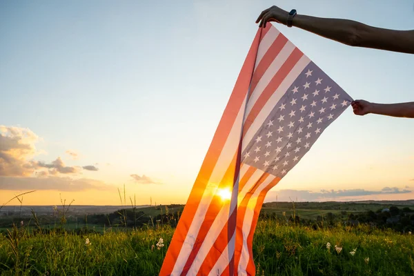 日没時にアメリカ国旗を手に手を振る — ストック写真