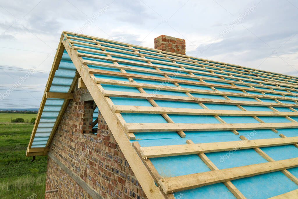 Aerial view of a wooden roof frame of brick house under construction.