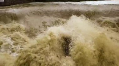 Şiddetli bahar yağmurları sırasında sel altında çamurlu suyla kirli nehrin havadan görünüşü.