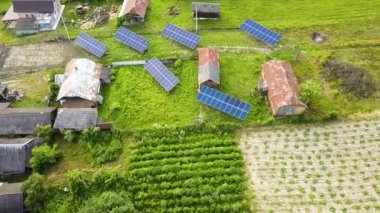 Yeşil kırsal alandaki güneş panellerinin yukarıdan aşağıya görüntüsü.