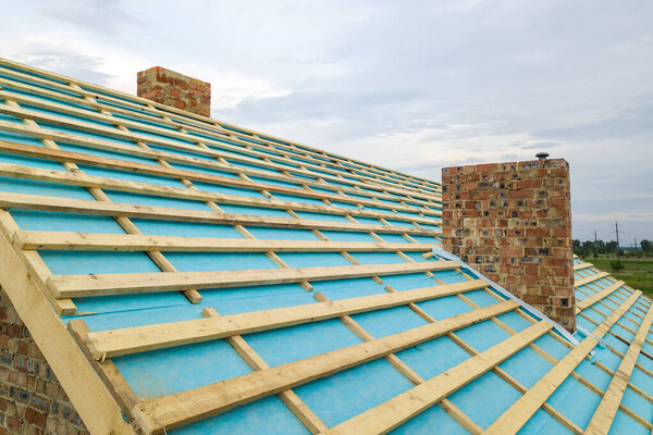 Вид с воздуха на деревянную крышу строящегося кирпичного дома.