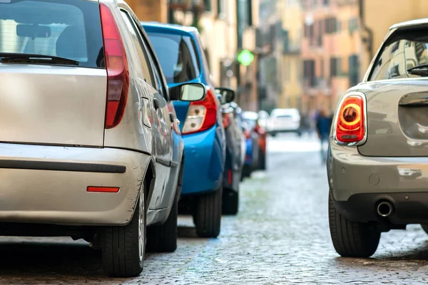 Modern cars parked on city street side in residential discrict. Shiny vehicles parked by the curb. Urban transportation infrastructure concept.