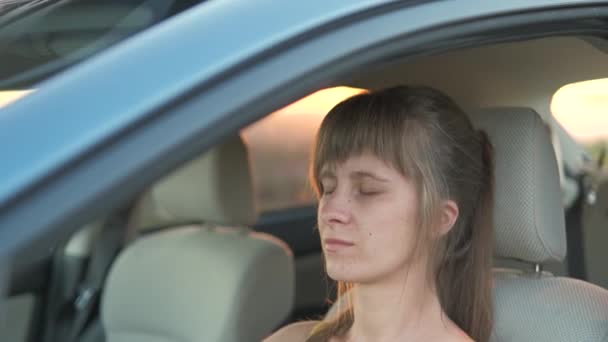 若い女性ドライバーリラックス彼女の車のホイールの後ろ — ストック動画