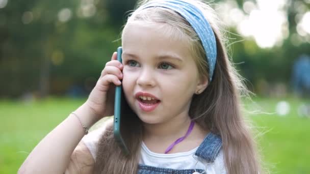 Счастливая Маленькая Девочка Разговаривает Телефону Летнем Парке — стоковое видео